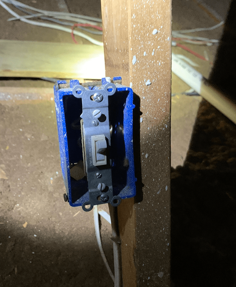 Light switch installed on wooden beam.