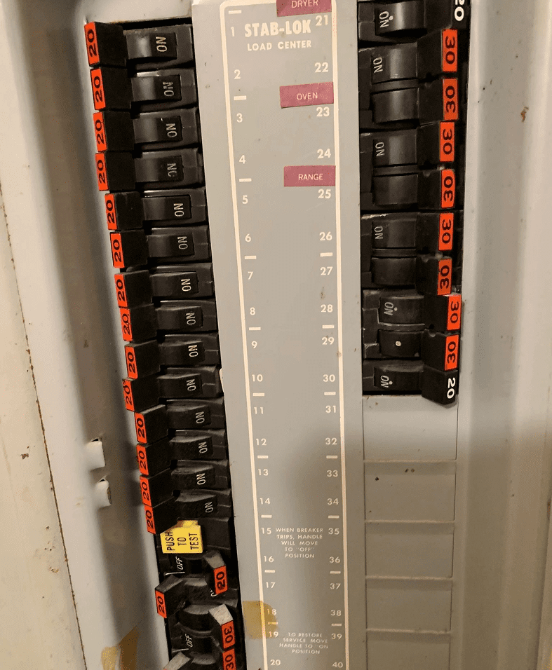 Electrical panel with labeled circuit breakers.