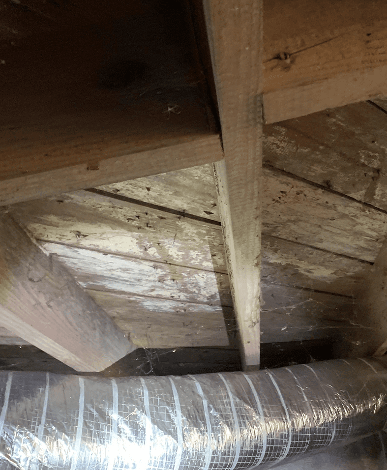 Wooden attic ceiling with ductwork visible.