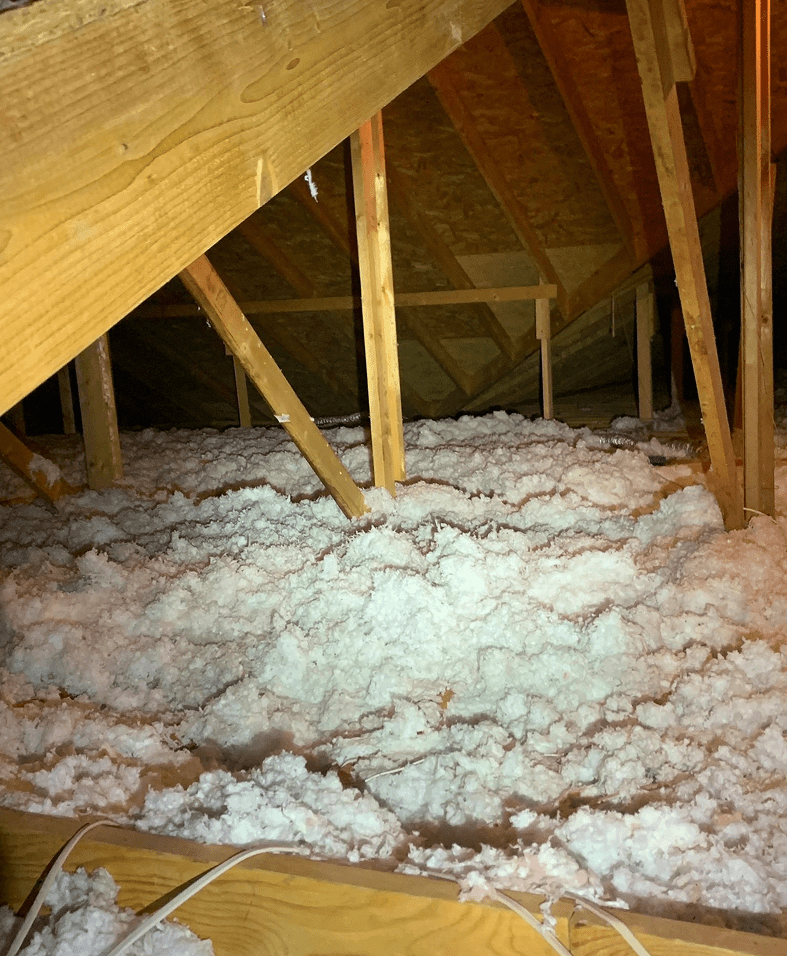 Attic with fluffy white insulation material.