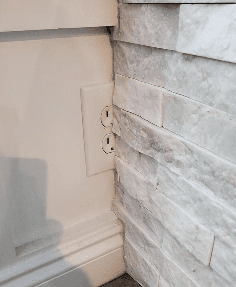 Outlet partially covered by stone wall.