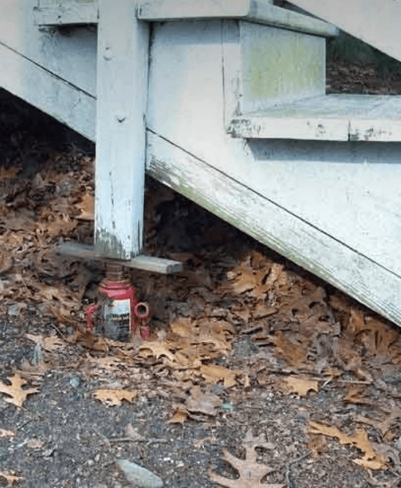 Staircase supported by a red hydraulic jack.