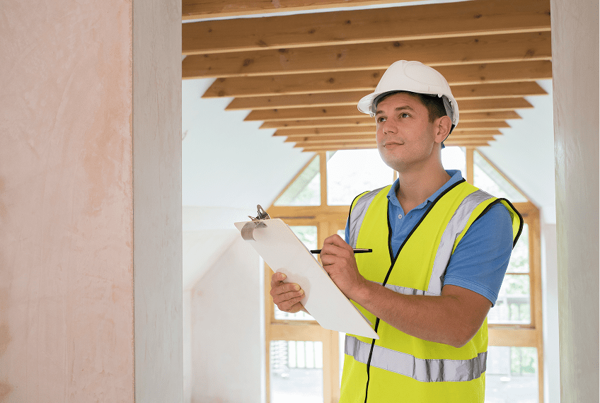 Construction worker with clipboard and hard hat.